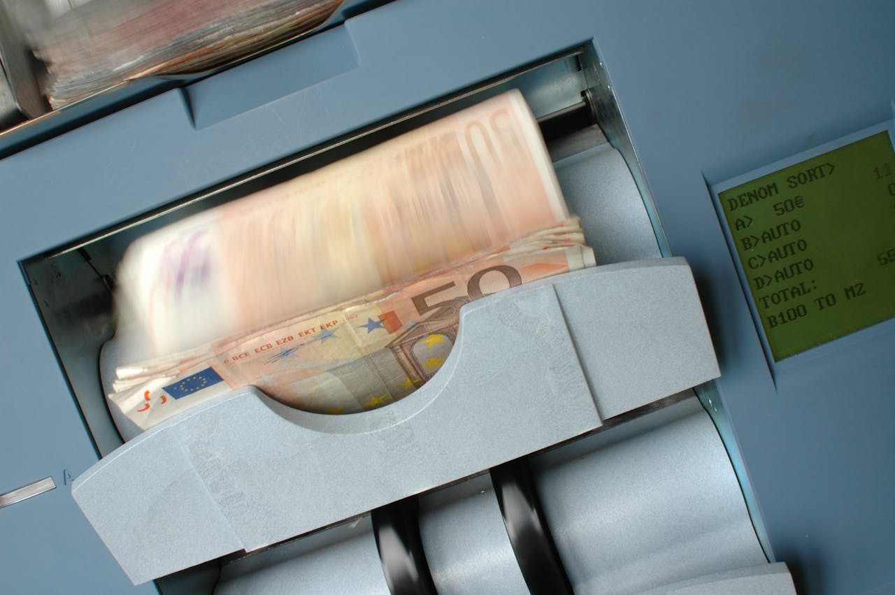 50 Euro banknotes being processed in a high-speed counting machine, showcasing technology and finance in action.