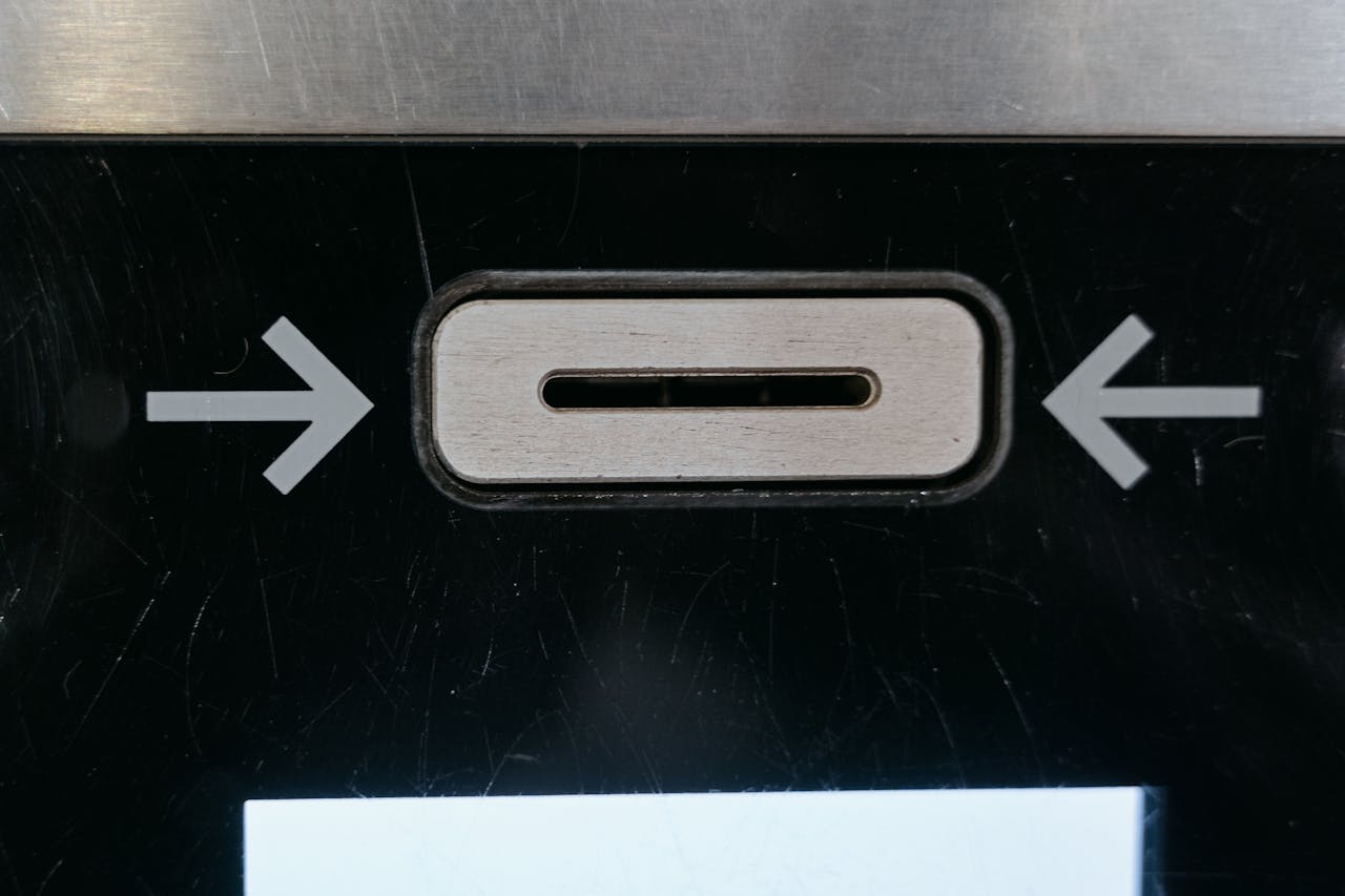 Detailed view of ATM card slot with directional arrows indicating card insertion direction.